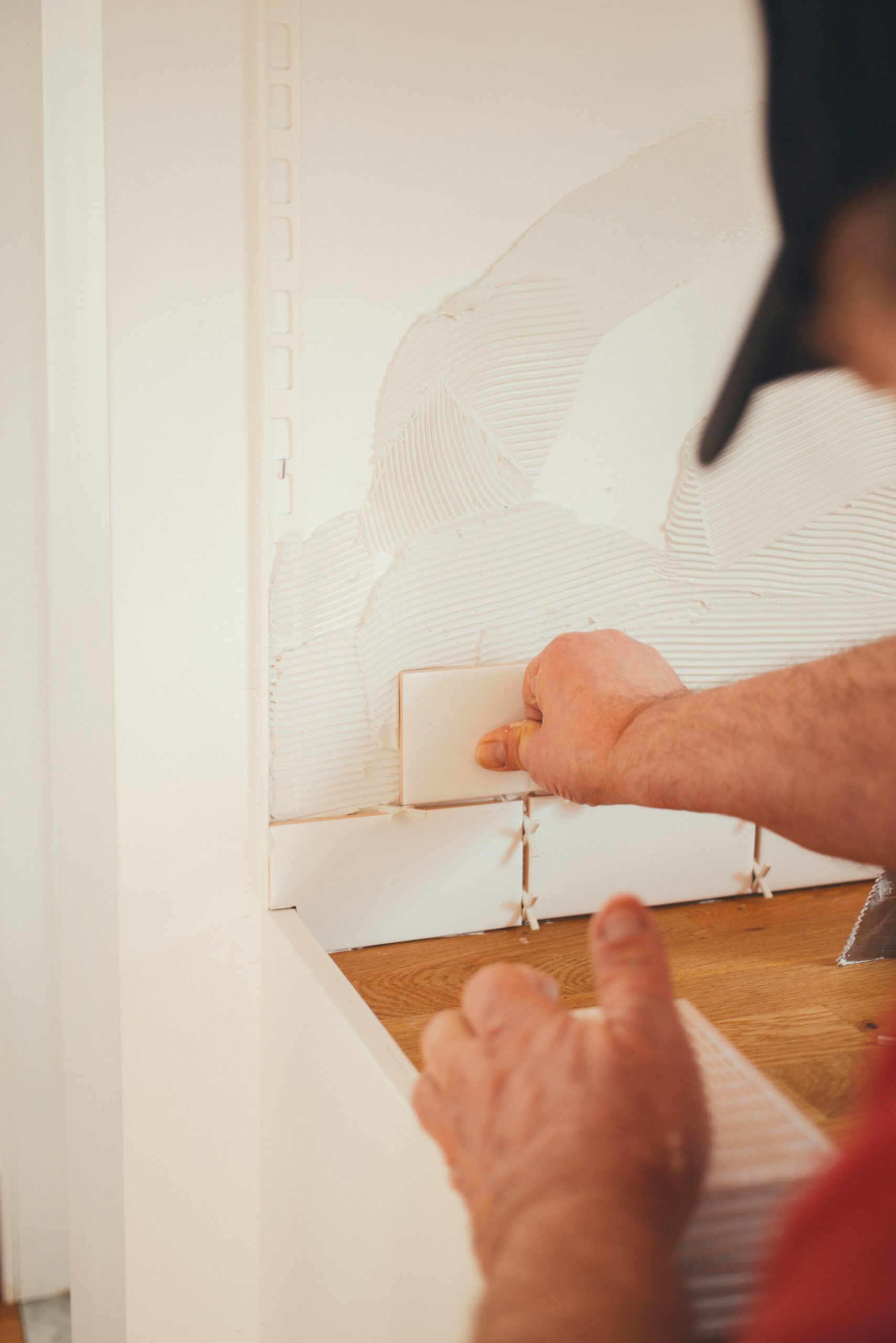 Trade worker installing backsplash for a kitchen renovation.
